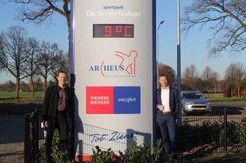 Jos Bongers van KroeseWevers (rechts) en Maurice Nijrolder van Archeus bij de nieuwe tijd- en temperatuurzuil op sportcomplex De Hunenbulten. Foto: Jan Ruesink 